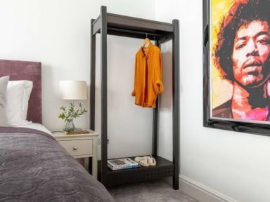 A bedroom with a wardrobe and a picture of a musician at By The Sea Newquay