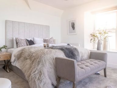 A bedroom with a bed and chair at By The Sea in Newquay