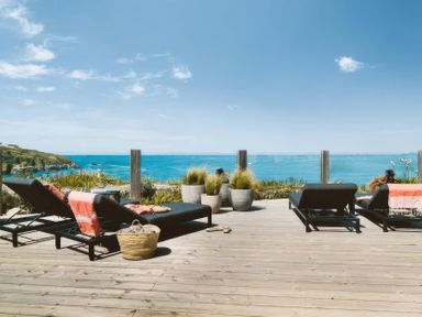An outdoor area with lounge chairs and planters at By The Sea Newquay