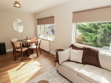 A living room with a round table and chairs at Flat 4 in Tenby