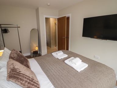 A bedroom with a bed and mirror at Flat 4 in Tenby