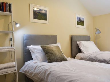 A bedroom with two beds and shelves at The Hayloft in Hexham
