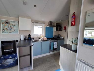 A kitchen with sink and stove at Lyons Sunnysands - Snowdon Summit 050 Talybont