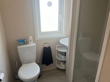 A bathroom with a toilet, sink, and shower at Lyons Sunnysands - Snowdon Summit 050 Talybont