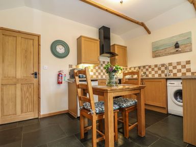 A kitchen with a table and chairs at Beech Cottage in Truro