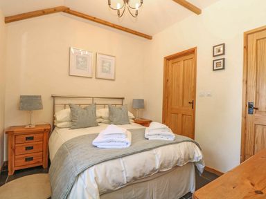 A bedroom with a bed and nightstands at Beech Cottage in Truro