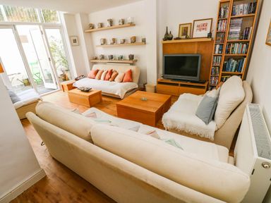 A living room with a sofa and coffee table at Basement Apartment in Tenby
