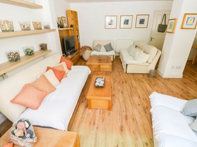 A living room with sofas and a coffee table at Basement Apartment in Tenby