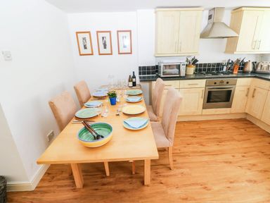 A dining room with a table set for dinner at Basement Apartment in Tenby