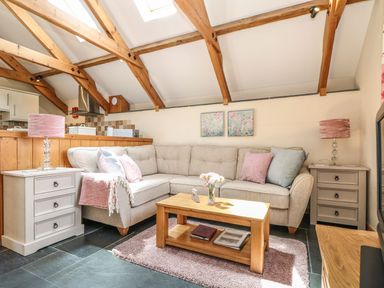 A living room with a sofa and coffee table at Oak Cottage in Truro