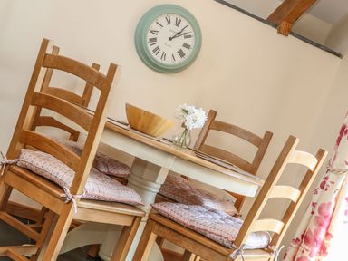 A dining room with a table and chairs at Oak Cottage in Truro