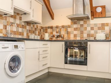 A kitchen with appliances and cabinetry at Oak Cottage in Truro