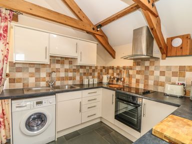 A kitchen with cabinets and appliances at Oak Cottage in Truro
