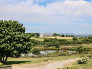 A scenic view with a pond and fields at Oak Cottage in Truro