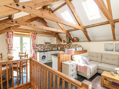 A living room with a sofa and table at Oak Cottage in Truro