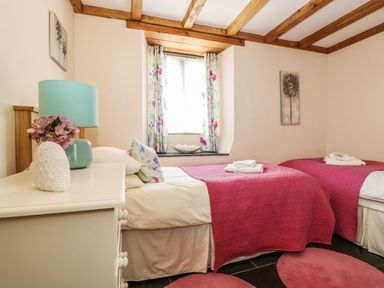 A bedroom with two beds and a lamp at Oak Cottage in Truro
