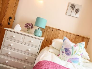 A bedroom with a bed and a chest of drawers at Oak Cottage in Truro