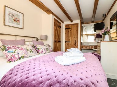 A bedroom with a bed and decorative items at Oak Cottage in Truro