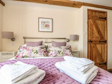 A bedroom with a bed and wooden door at Oak Cottage in Truro