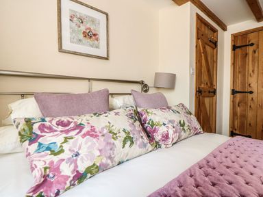 A bedroom with a bed and decorative pillows at Oak Cottage in Truro