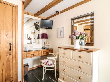 A hallway with a mirror and dresser at Oak Cottage in Truro