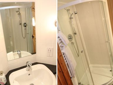 A washbasin and shower enclosure at Oak Cottage in Truro