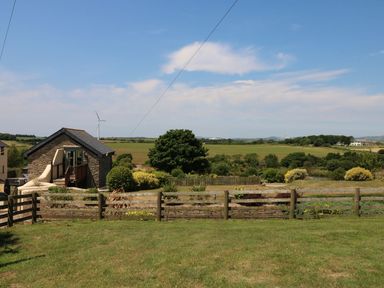 A house with a fence and grass field at Oak Cottage in Truro