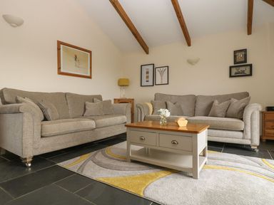 A living room with a sofa and table at Hawthorn Cottage in Truro