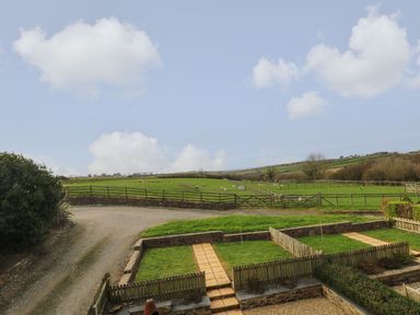 A field with fences and a gravel path at Hawthorn Cottage in Truro