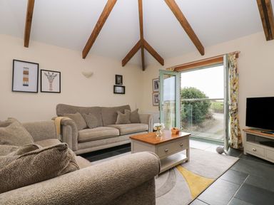 A living room with a sofa and coffee table at Hawthorn Cottage in Truro