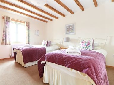 A bedroom with two beds and a window at Hawthorn Cottage in Truro