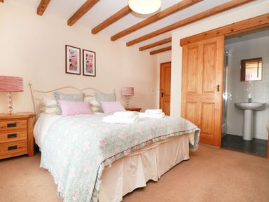 A bedroom with a double bed and adjoining bathroom at Hawthorn Cottage in Truro
