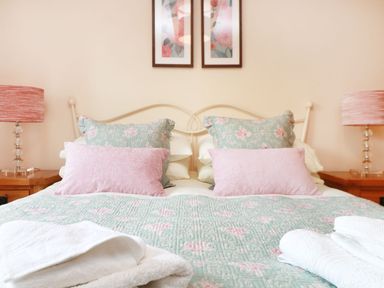 A bedroom with a bed and lamps at Hawthorn Cottage in Truro