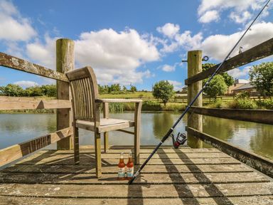A fishing dock with a chair and bottles at Hawthorn Cottage in Truro