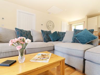 A living room with a sofa and a table at Elm Cottage in Truro