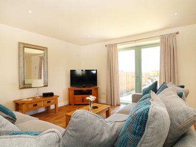 A living room with a sofa and television at Elm Cottage in Truro