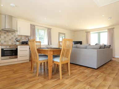 An open plan living area with a dining table and sofa at Elm Cottage in Truro