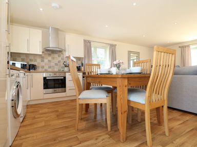 A kitchen with wooden table and chairs at Elm Cottage in Truro