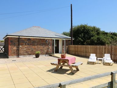 An outdoor patio with a picnic table and chairs at Elm Cottage in Truro