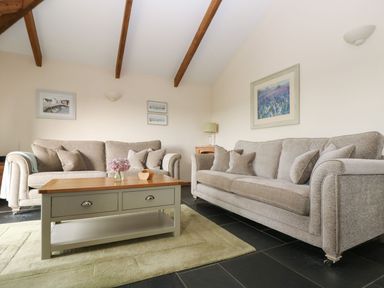 A living room with sofas and a coffee table at Ash Cottage in Truro