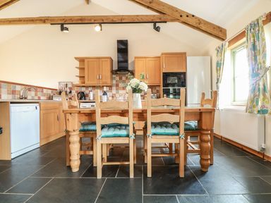 A kitchen with a dining table and chairs at Ash Cottage in Truro