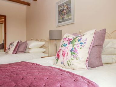 A bedroom with two beds and decorative pillows at Ash Cottage in Truro
