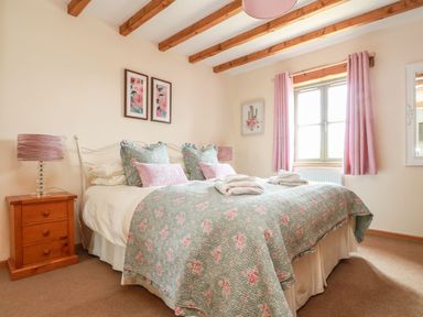 A bedroom with a bed and nightstand at Ash Cottage in Truro