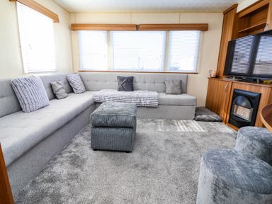 A living room with a sofa and television at Beach Fields 45 in Kinmel Bay