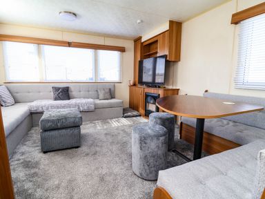 A living room with a television and sofa at Beach Fields 45 in Kinmel Bay