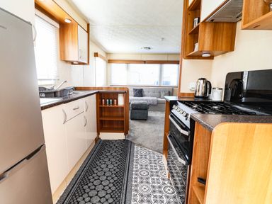 A kitchen with appliances and living area at Beach Fields 45 Kinmel Bay