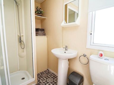 A bathroom with a shower, sink, and toilet at Beach Fields 45 in Kinmel Bay