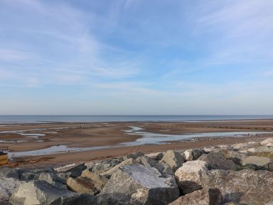 A coastal view with rocks and a pier at Beach Fields 45 in Kinmel Bay