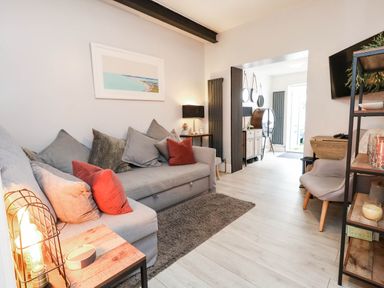 A living room with a sofa, table, and decorative items at Flat 1, 2 Wooperton Street Weymouth