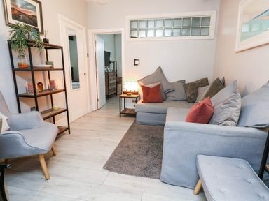 A living room with sofa and bookshelf at Flat 1, 2 Wooperton Street Weymouth